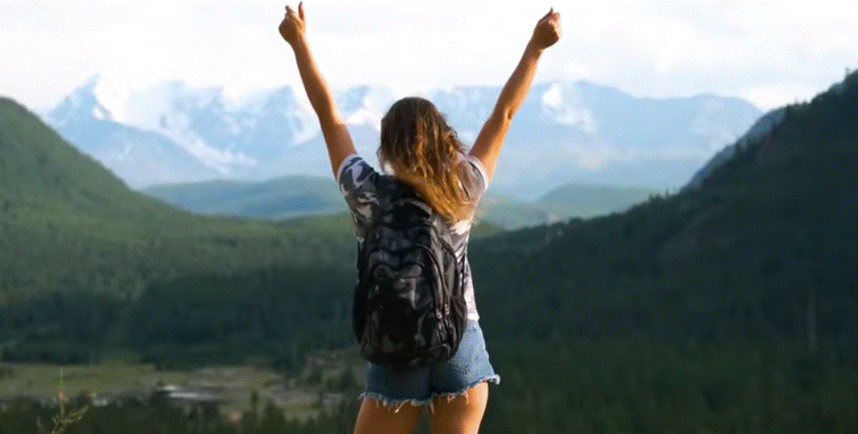 Traveler with backpack enjoying mountain view promoting green travels and eco tourism