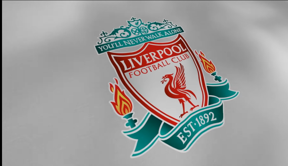 “Official crest of Liverpool Football Club featuring the Liver bird, ‘You’ll Never Walk Alone’ banner, eternal flames, and ‘Est. 1892’ on a clean background.”
